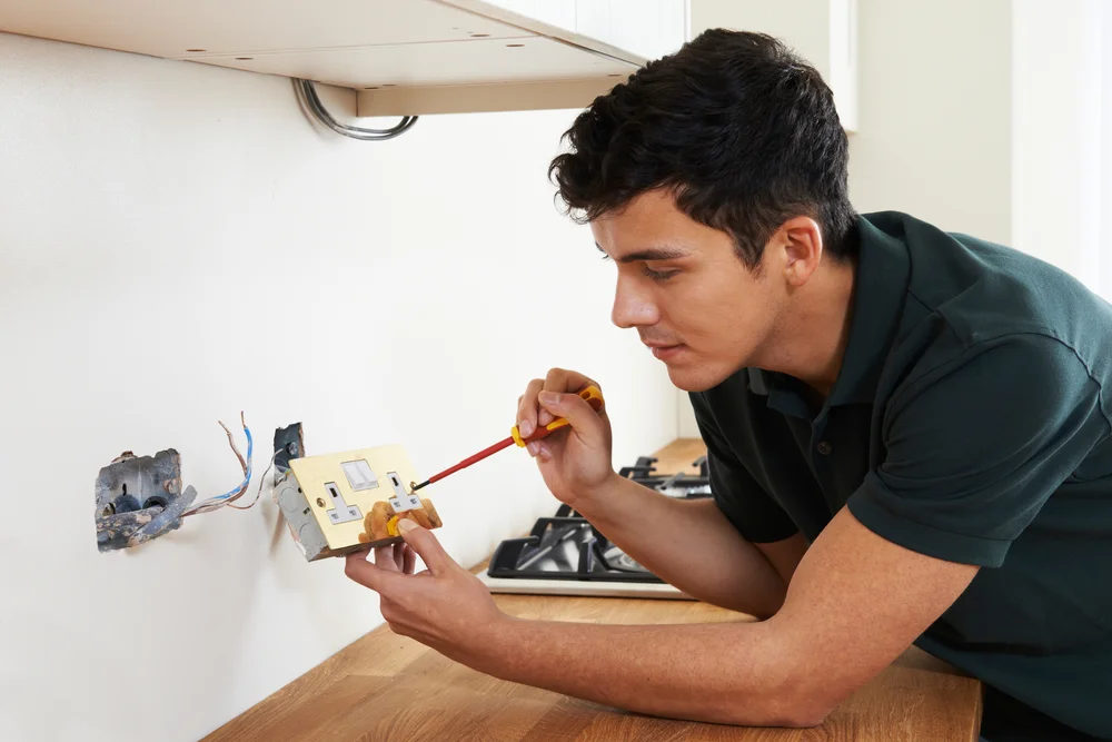Electrician repairing a domestic wall socket